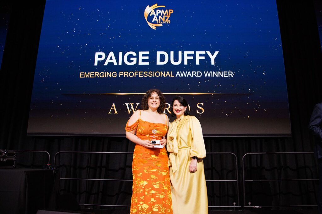 BidWrite's Paige Duffy with her APMP Emerging Professional Award, presented by Leann Webb of Aurora Marketing