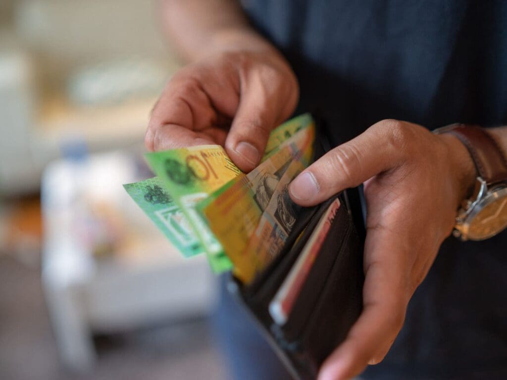 Man holding Australian $50 notes - representing BidWrite's monetary donations as part of community impact program