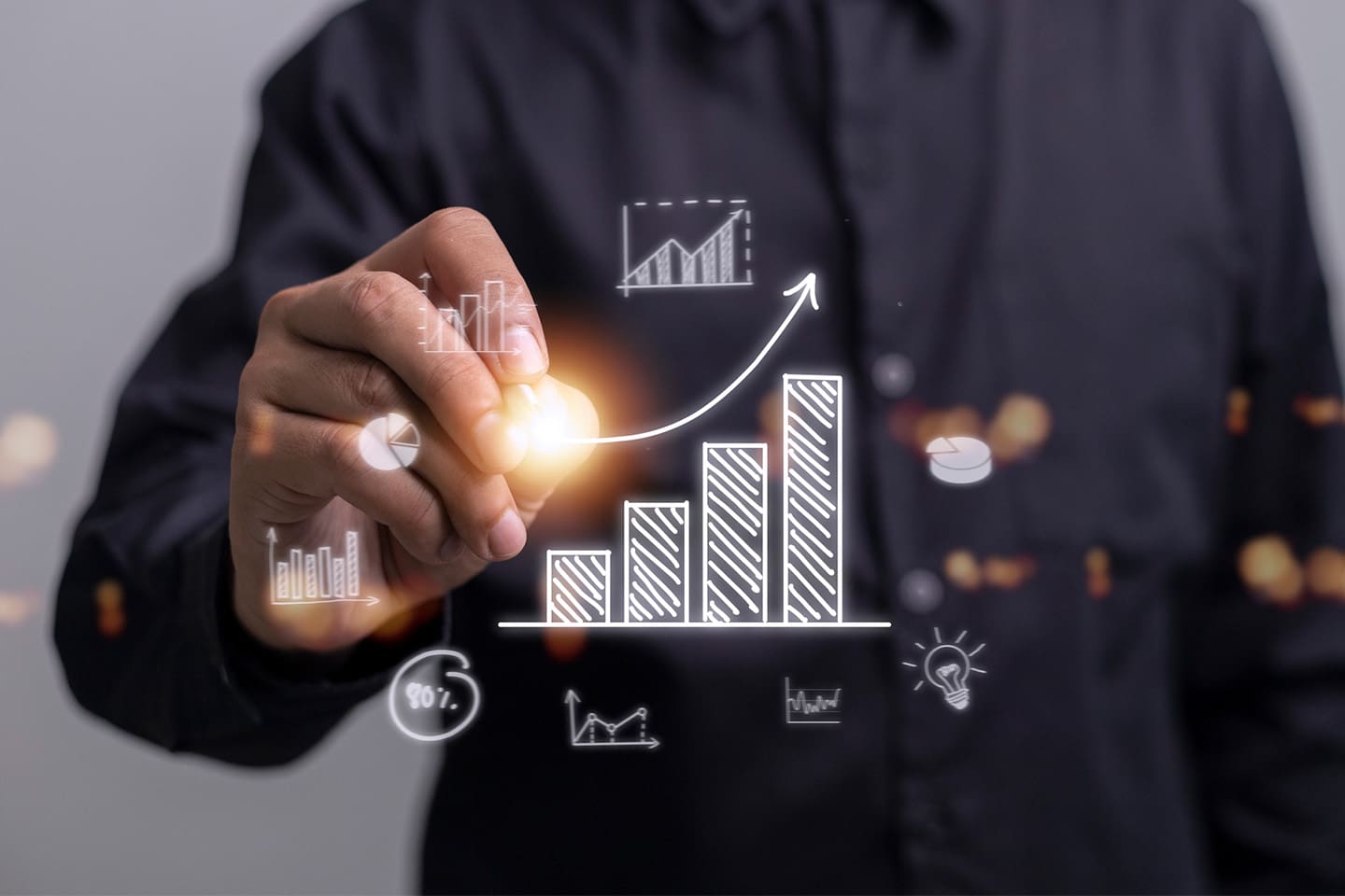 Conceptual image of a professional man drawing an upwards trend line on a graph.