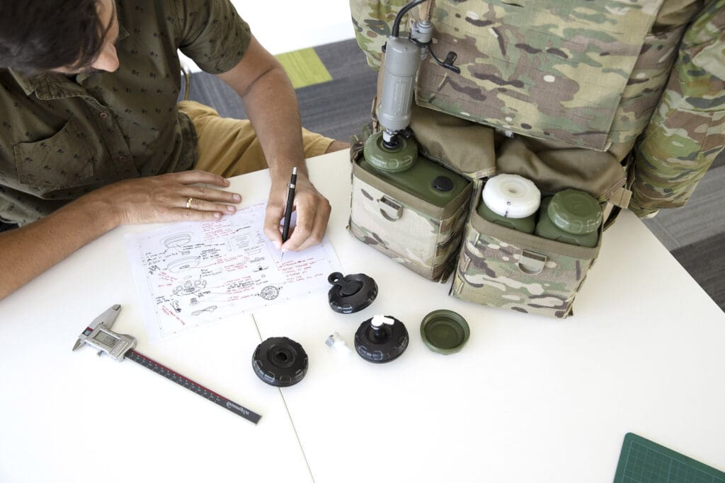 Soldier with adventure equipment handwriting notes on a tactical Defence plan