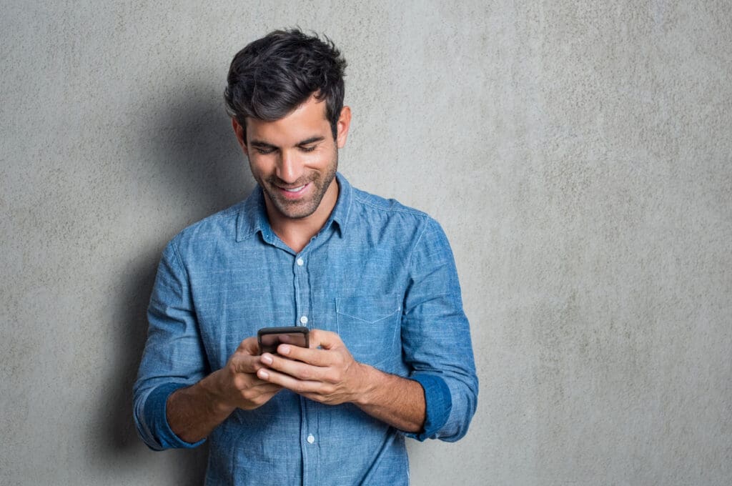 A man in collared shirt looks at his phone and compares dating apps ('tindering') to procurement processes (tendering)